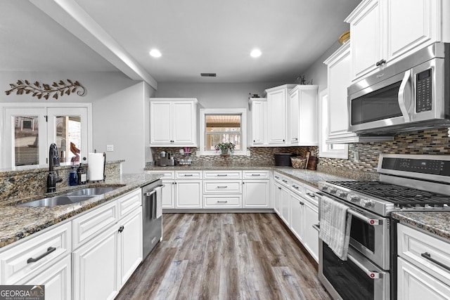 45 Misty Creek Cv, Newnan, GA 30265 - living area with wood finished floors, vaulted ceiling, a stone fireplace, baseboards, and a ceiling fan