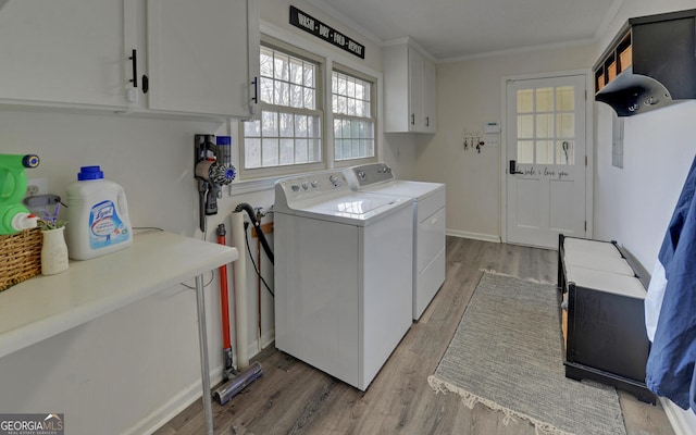 laundry room featuring crown molding, cabinets, separate washer and dryer, and light wood-type flooring