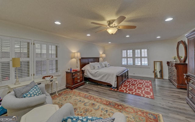 bedroom featuring ornamental molding, a textured ceiling, ceiling fan, and light hardwood / wood-style floors