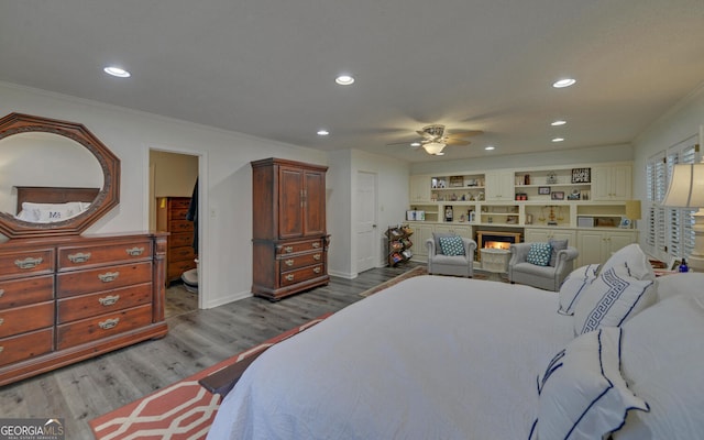 bedroom featuring ceiling fan, crown molding, and light hardwood / wood-style floors