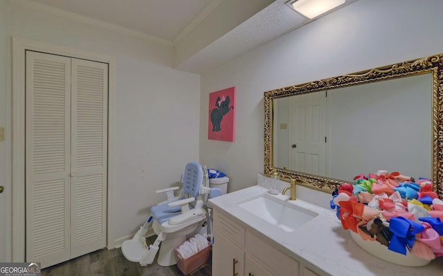 bathroom featuring vanity, hardwood / wood-style floors, ornamental molding, and toilet