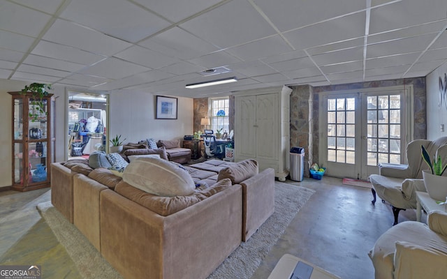 living room with a drop ceiling and french doors