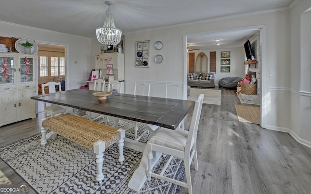 dining area featuring crown molding, light hardwood / wood-style floors, and a textured ceiling