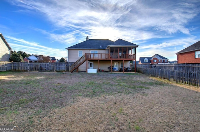 back of property with a yard, a deck, and a sunroom