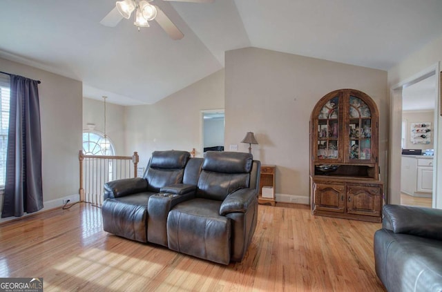 living room featuring lofted ceiling, ceiling fan, and light wood-type flooring