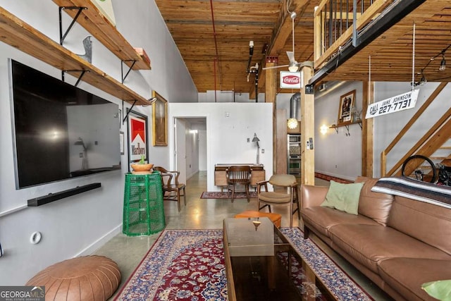 living room featuring beam ceiling, a high ceiling, and wooden ceiling