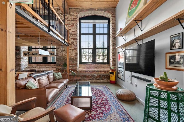 living room with wooden ceiling, a high ceiling, and brick wall