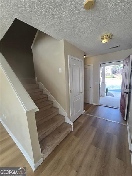 entryway with hardwood / wood-style flooring and a textured ceiling