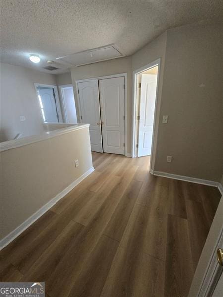 empty room featuring wood-type flooring and a textured ceiling