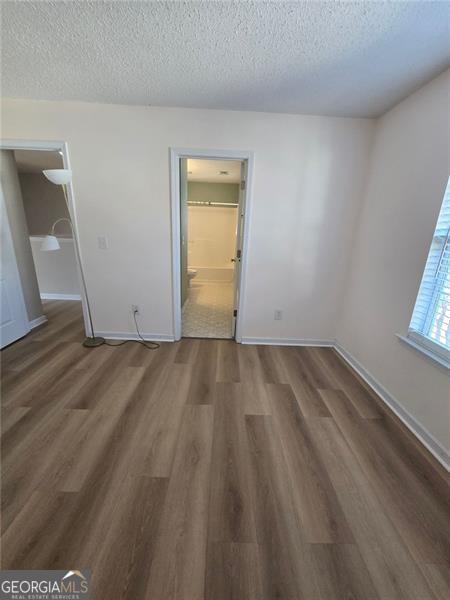 unfurnished room with dark hardwood / wood-style floors and a textured ceiling