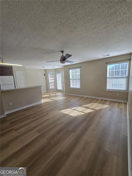 unfurnished room with dark hardwood / wood-style floors, a textured ceiling, and ceiling fan