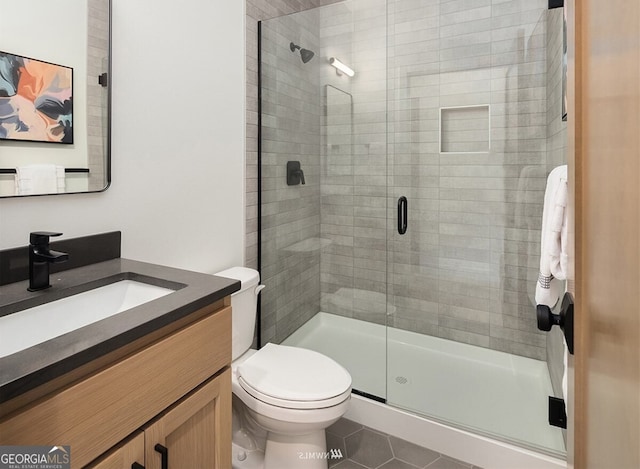 bathroom with an enclosed shower, vanity, tile patterned floors, and toilet