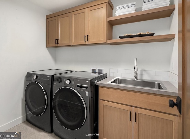 laundry area featuring cabinets, sink, and washer and clothes dryer