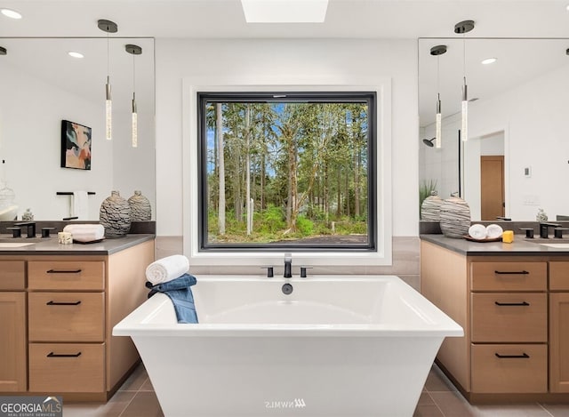 bathroom with tile patterned flooring, vanity, plenty of natural light, and a bathing tub