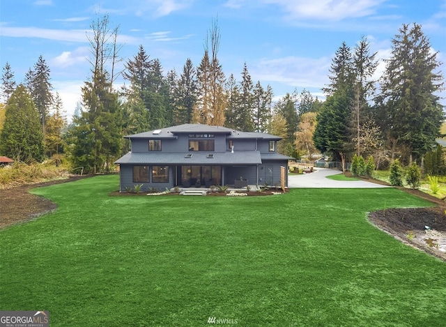 rear view of property featuring a lawn