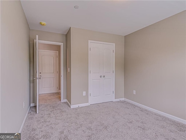 unfurnished bedroom featuring carpet and baseboards