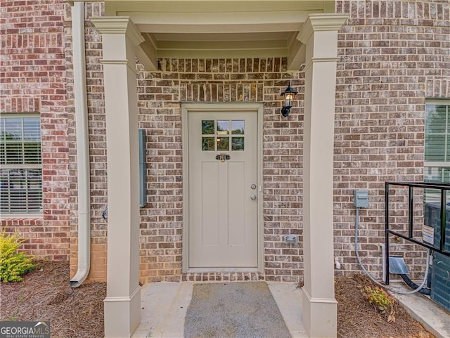 view of exterior entry with brick siding