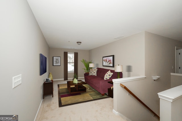 living room with light carpet, visible vents, and baseboards