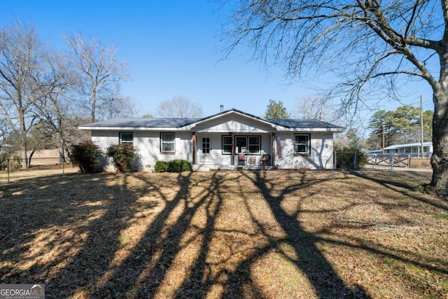 ranch-style house with a porch and a front lawn