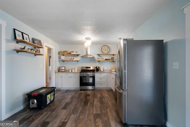 kitchen with stainless steel appliances, white cabinetry, dark wood-type flooring, and wall chimney range hood