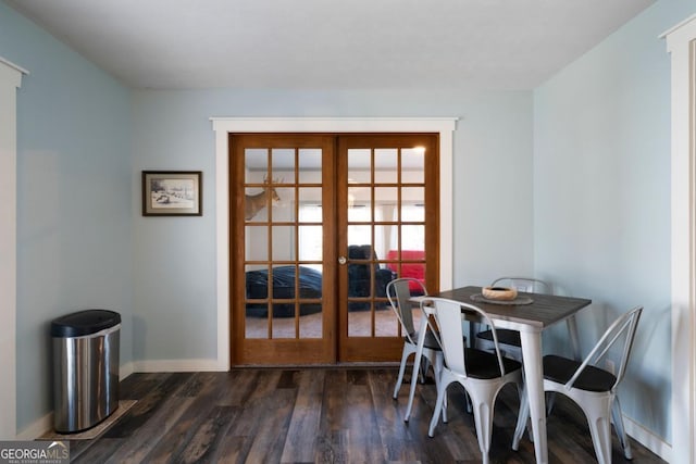 dining room with dark hardwood / wood-style floors and french doors