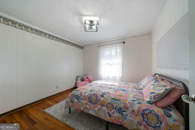 bedroom featuring wood-type flooring and ornamental molding