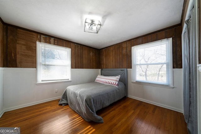 bedroom featuring multiple windows and dark hardwood / wood-style floors