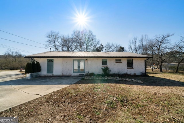 single story home with a front lawn and french doors