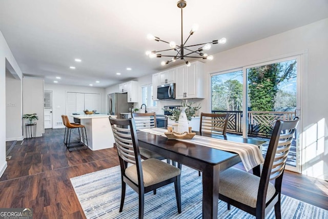 dining area with dark wood-type flooring and an inviting chandelier