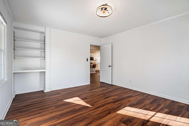 unfurnished bedroom featuring dark wood-type flooring and crown molding