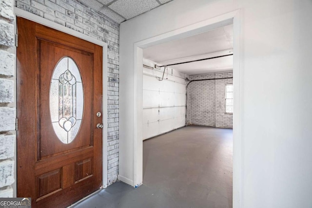 foyer entrance featuring brick wall