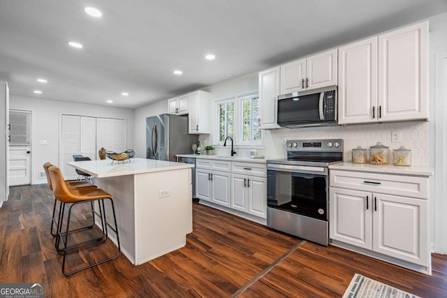 kitchen featuring white cabinetry, a kitchen island, tasteful backsplash, and appliances with stainless steel finishes