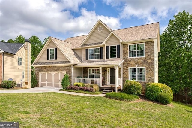 view of front of house featuring a garage, a front yard, and covered porch