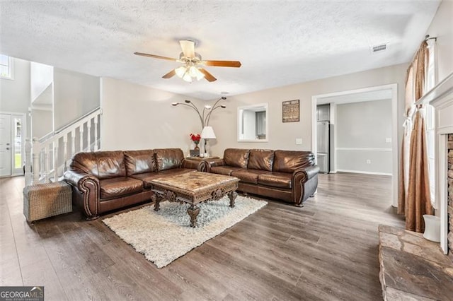 living room with a healthy amount of sunlight, dark hardwood / wood-style floors, and a textured ceiling