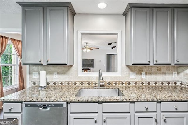 kitchen with gray cabinets, sink, stainless steel dishwasher, and light stone counters