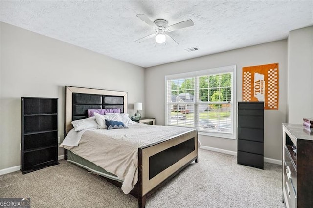 carpeted bedroom with a textured ceiling and ceiling fan