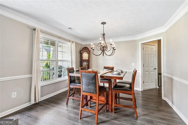 dining space with crown molding, dark hardwood / wood-style floors, and an inviting chandelier