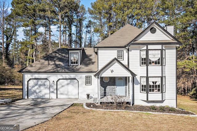 view of front of home with a garage, a front yard, and a porch