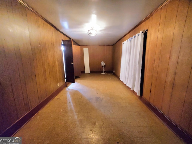 interior space with crown molding and wood walls