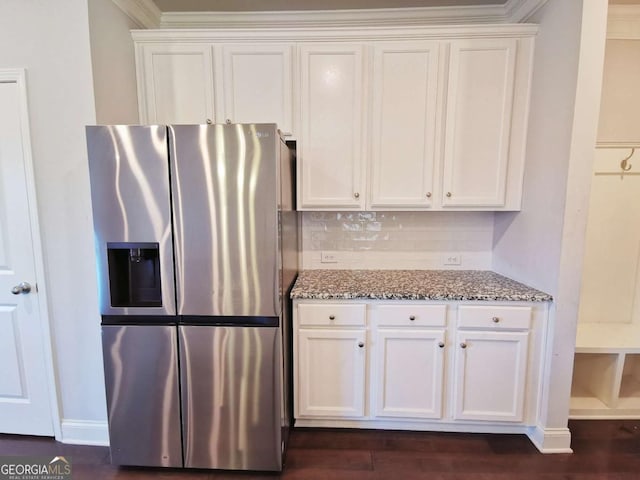 kitchen featuring stone countertops, tasteful backsplash, white cabinetry, crown molding, and stainless steel refrigerator with ice dispenser