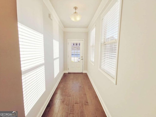 entryway with crown molding and dark wood-type flooring