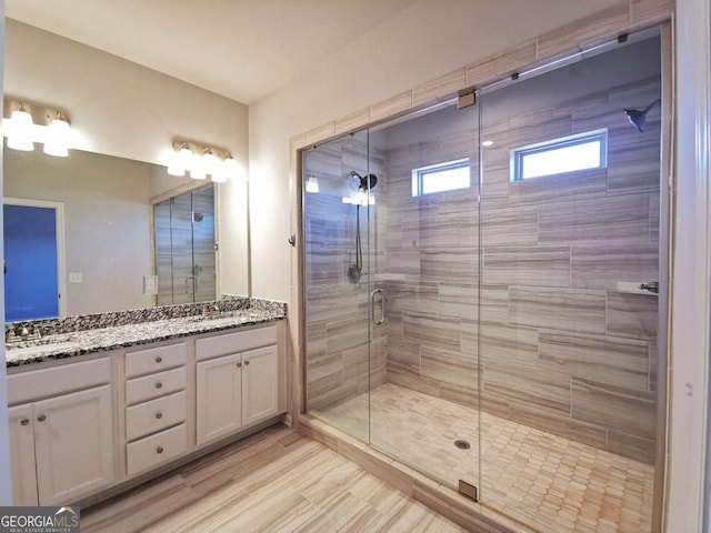 bathroom featuring walk in shower and vanity