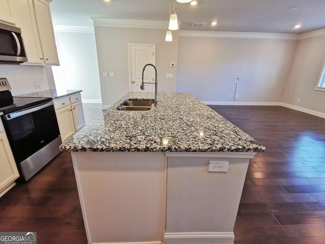 kitchen featuring sink, stainless steel appliances, light stone countertops, and a center island with sink