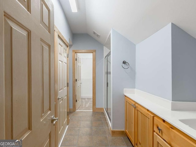 bathroom with a shower with door and vaulted ceiling