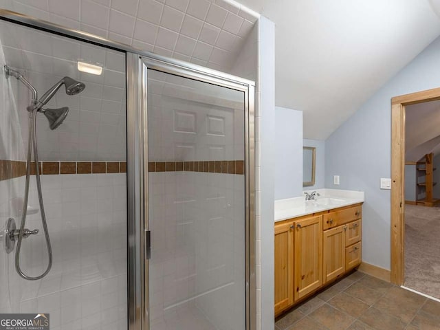 bathroom with vaulted ceiling, vanity, and a shower with door