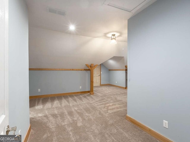 bonus room with lofted ceiling and light carpet