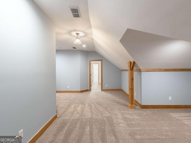 bonus room with lofted ceiling and light colored carpet