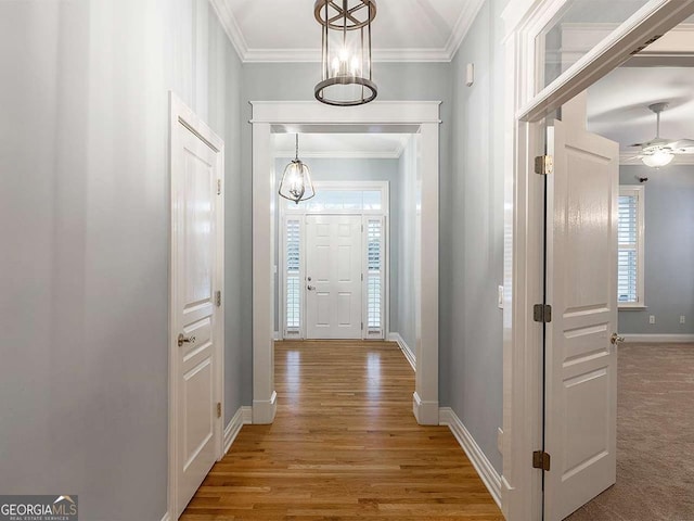 hallway with hardwood / wood-style flooring and ornamental molding