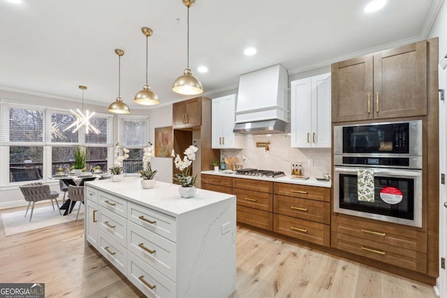 kitchen featuring custom exhaust hood, white cabinetry, tasteful backsplash, pendant lighting, and stainless steel appliances