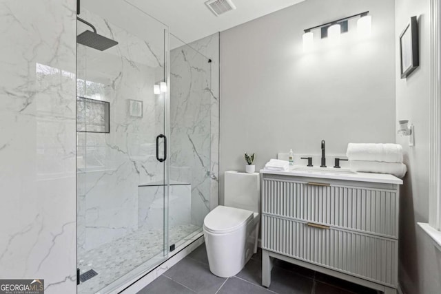 bathroom featuring vanity, a shower with shower door, tile patterned floors, and toilet